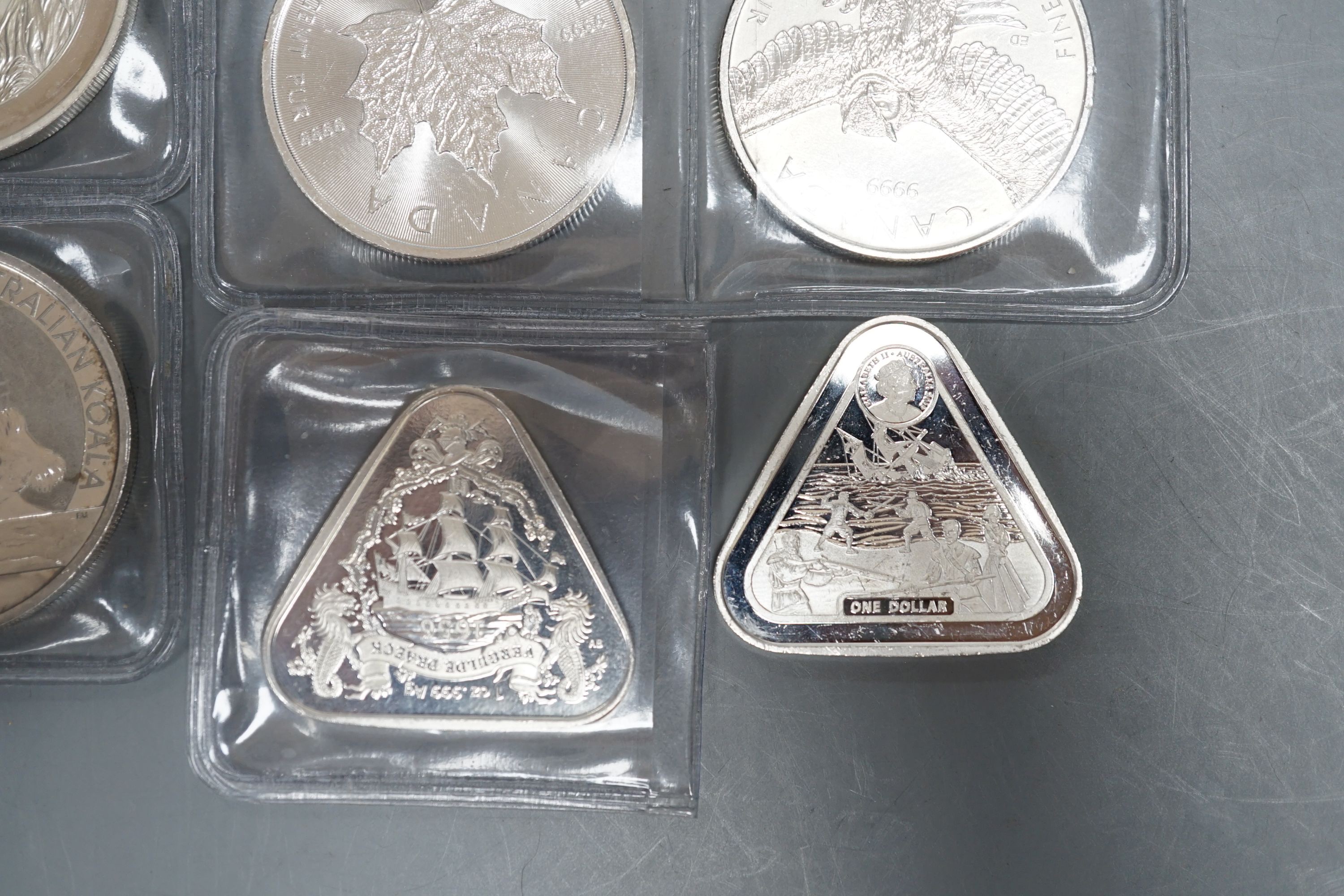 Eight 1oz assorted Australian 1 dollar coins, finesse .999, four 1oz assorted Canadian dollar coins, two silver 1oz coins- Britannia 2019 and George & Dragon, 2021 and two silver Australian triangular 1oz coins, 2019/202